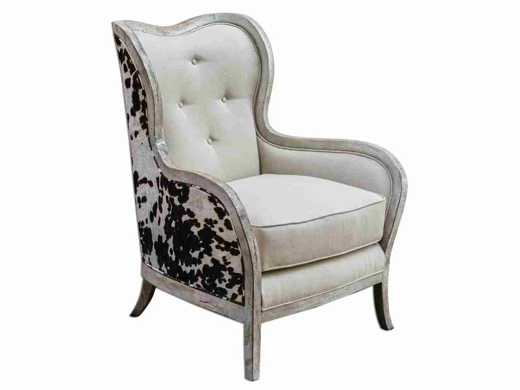 The Living Room Uttermost Chalina High Back Armchair 23611 offers a curvy, exposed wood frame. The white velvet fuses uniquely with the linen box cushion, giving it an exceptional look. 
